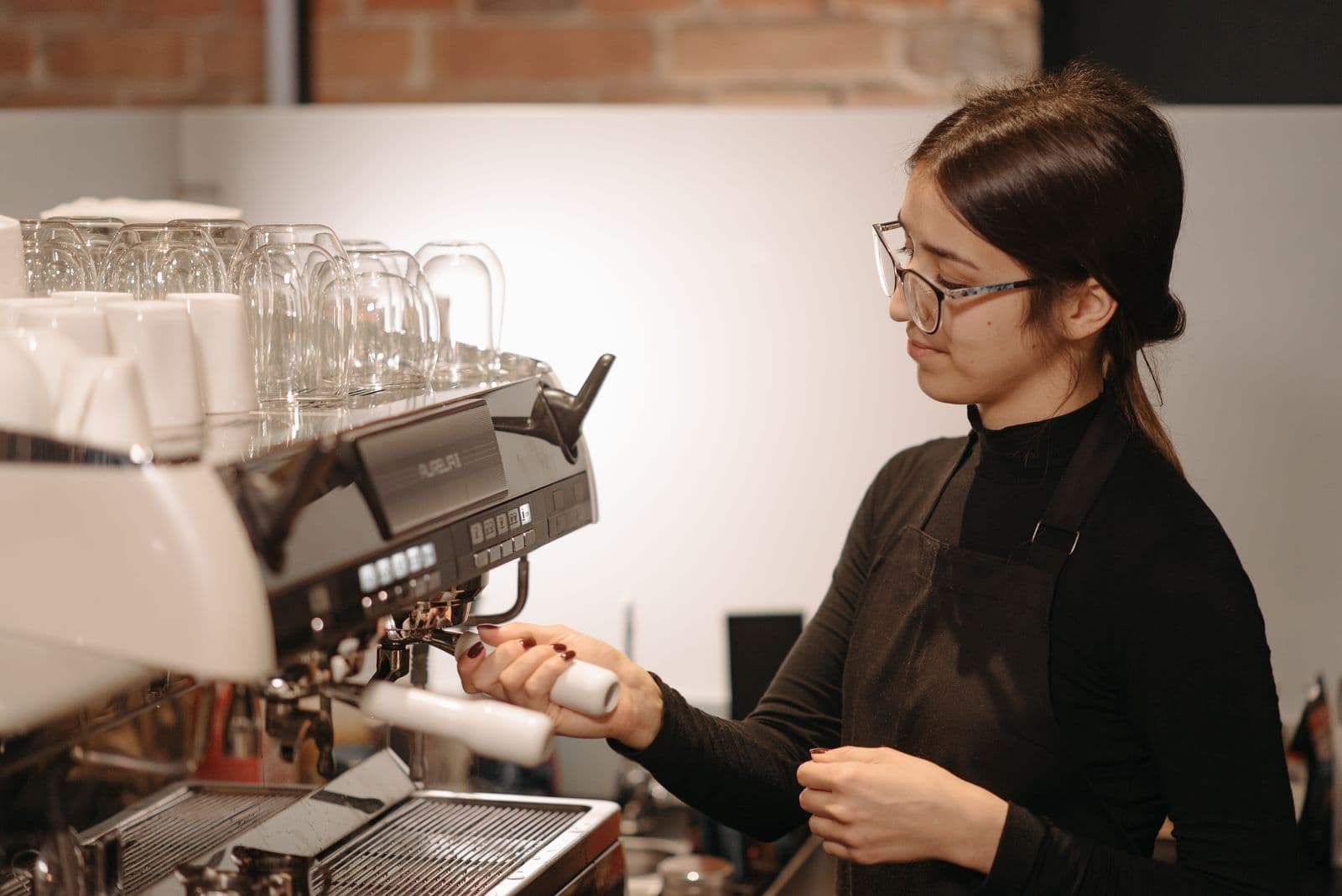 Barista steaming milk at the espresso machine